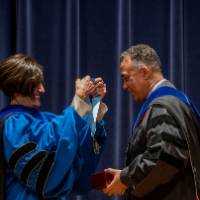 Provost giving a medallion to a faculty member